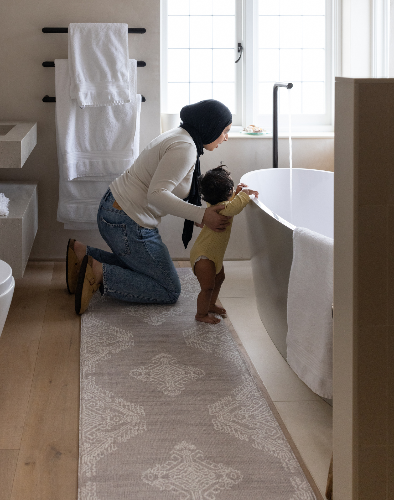 Mother and baby prepare for bath time keeping comfortable on the memory foam bath room mat the sepi with a grey design that sits subtly in modern bathroom designs also use the mat as a kitchen mat runner or exercise mat in the home 