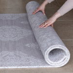 Hands unroll thick one piece playmat featuring two grey motifs The Sepi and The Sunda versatile modern designs to complement contemporary family homes