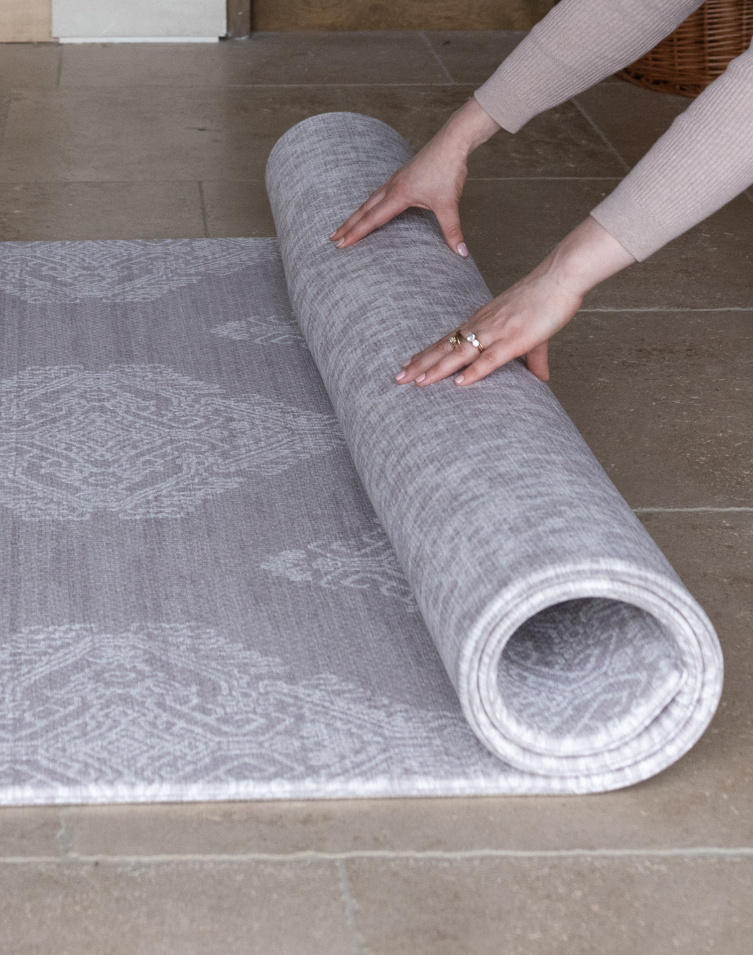 Hands unroll thick one piece playmat featuring two grey motifs The Sepi and The Sunda versatile modern designs to complement contemporary family homes