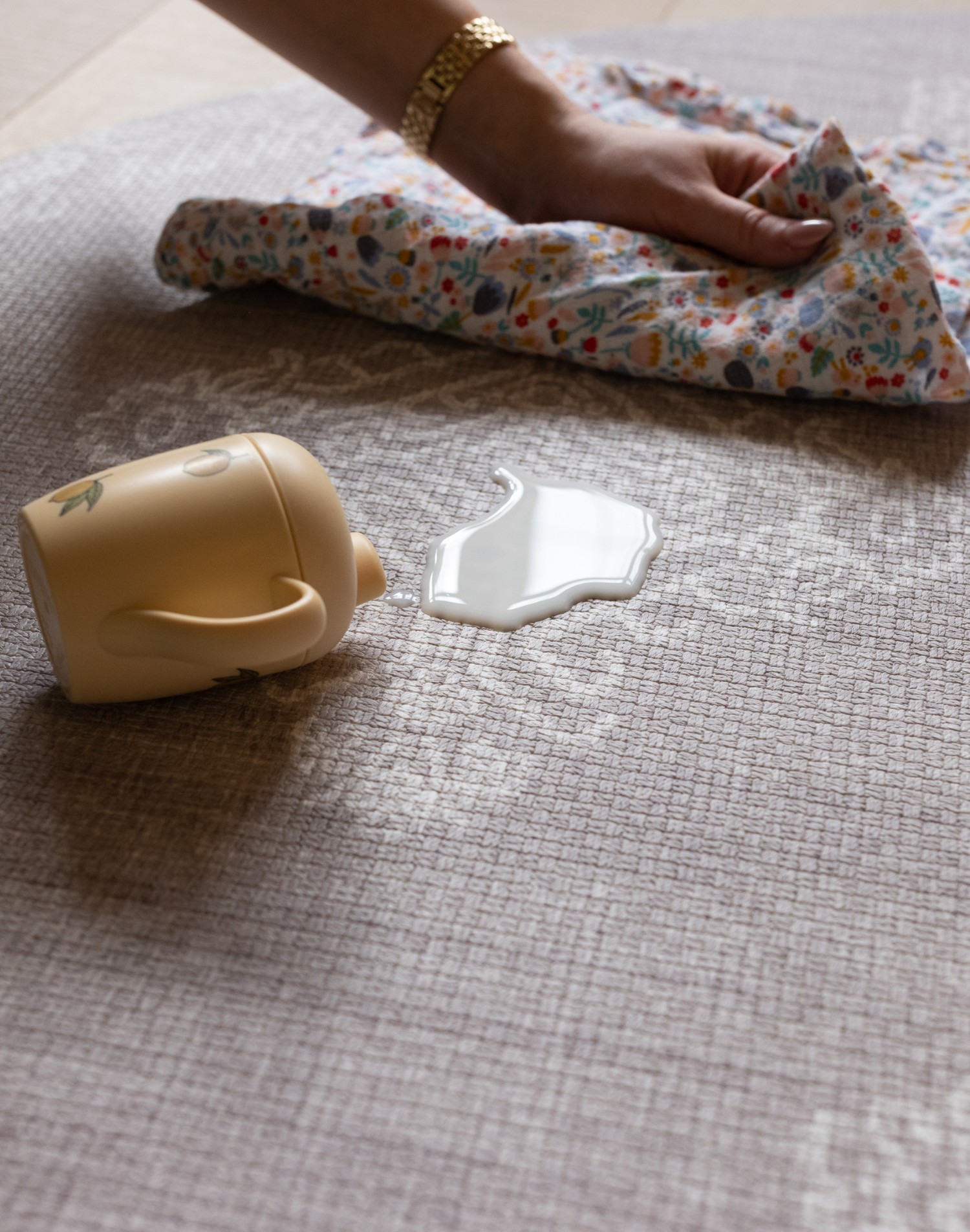 Hand wipes up milk spill on waterproof play mat the sepi that allows for easy cleaning in the family home and does not harbour dirt or dust an allergy friendly play mat option