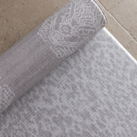 Close up of the grey animal print playmat with a textural batik inspired rug design on the rug unroll on hard wood tiled or carpeted flooring for support and comfort for the whole family 