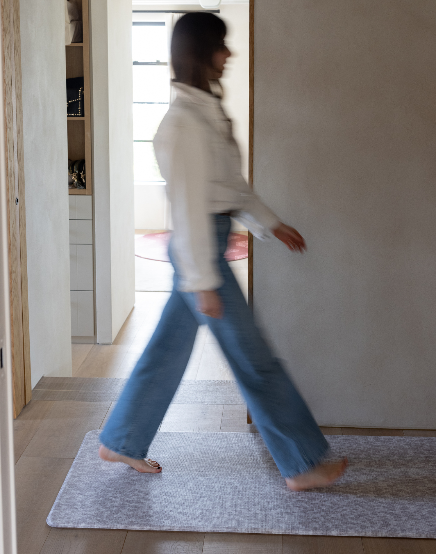 Lady walks across the leopard print hallway runner mat providing warm and protection underfoot on hard wood flooring