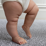 Little legs are supported on the memory foam surface of totter and tumble leopard baby playmat 