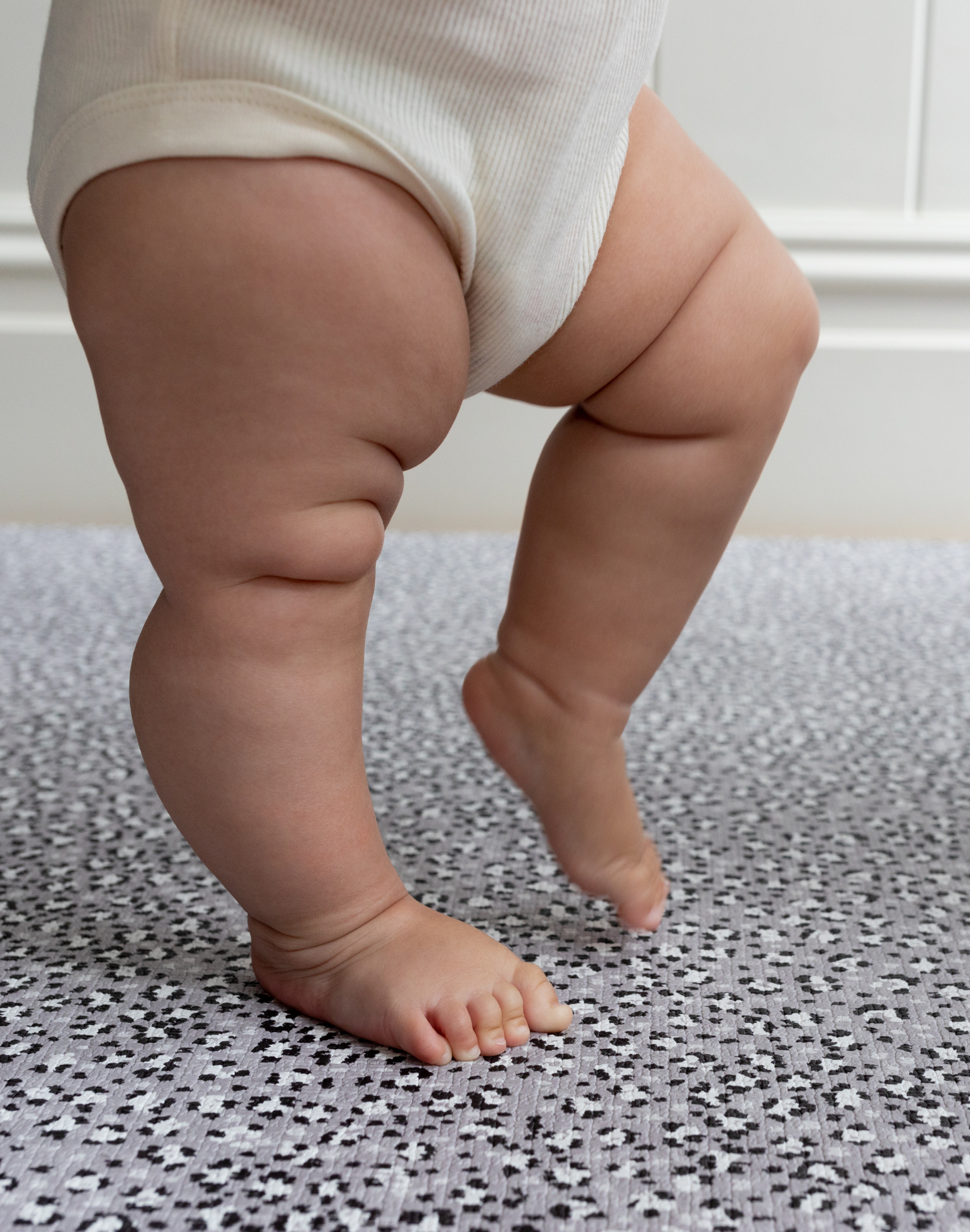 Little legs are supported on the memory foam surface of totter and tumble leopard baby playmat 