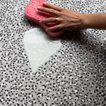 Wiping up milk spillage with sponge on wipeable playmat by totter and tumble 