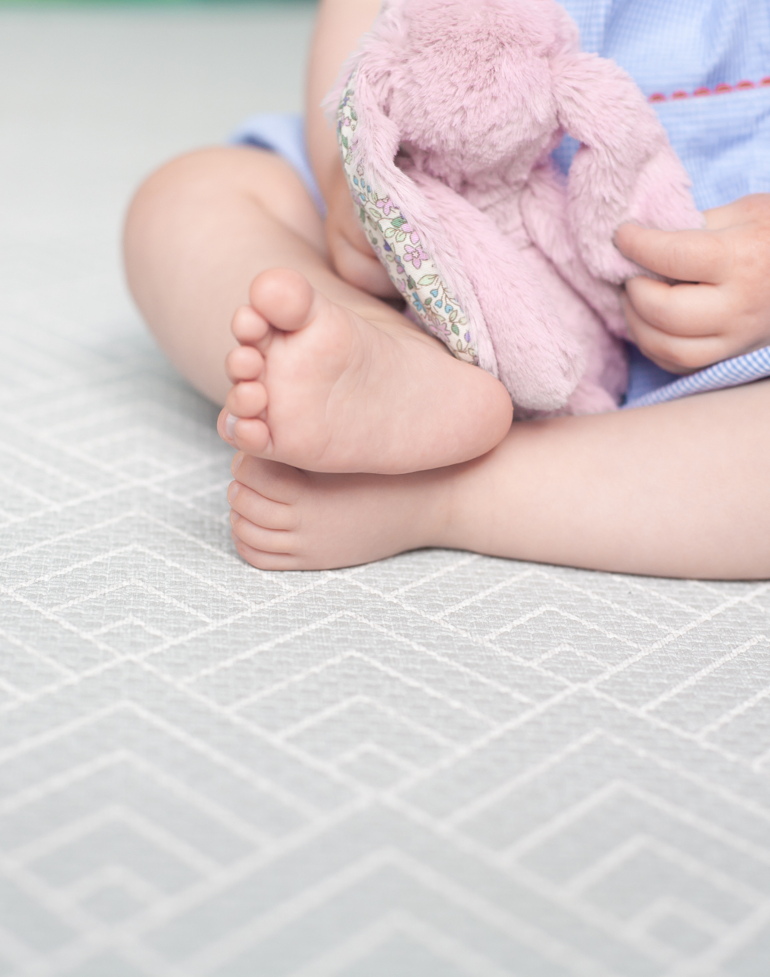 Baby feet rest on foam playmat providing support and protection for sitting