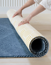 Unrolling thick one piece play rug by Totter and Tumble with Wanderlust design and honeycomb Keeper on the reverse 