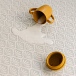 Split milk on the beachcomber shell coastal inspired design playmat from totter and tumble, non toxic and easy to clean