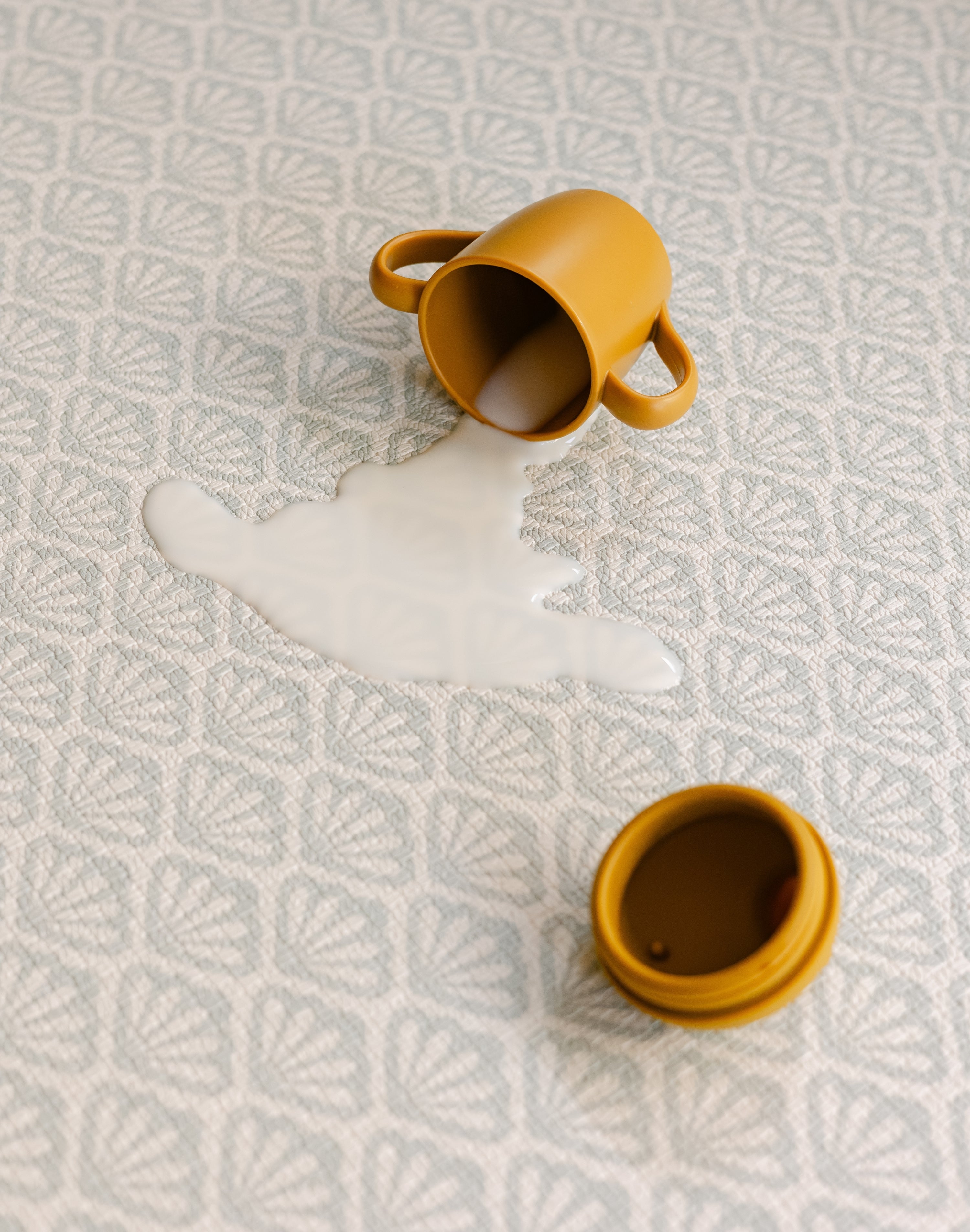 Split milk on the beachcomber shell coastal inspired design playmat from totter and tumble, non toxic and easy to clean