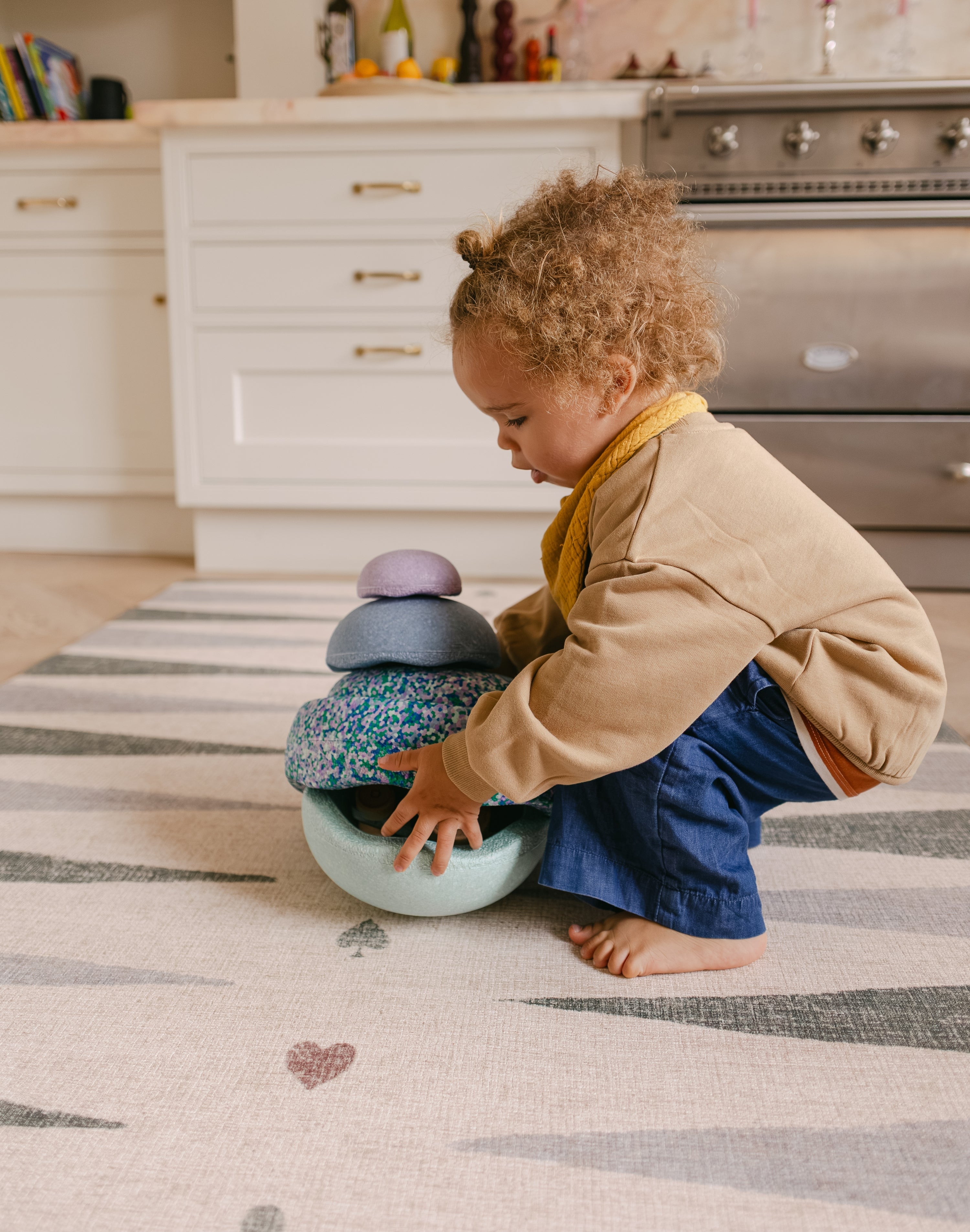 Toddler stacking on The Counter, Totter + Tumble wipeable and reversible memory foam playmat