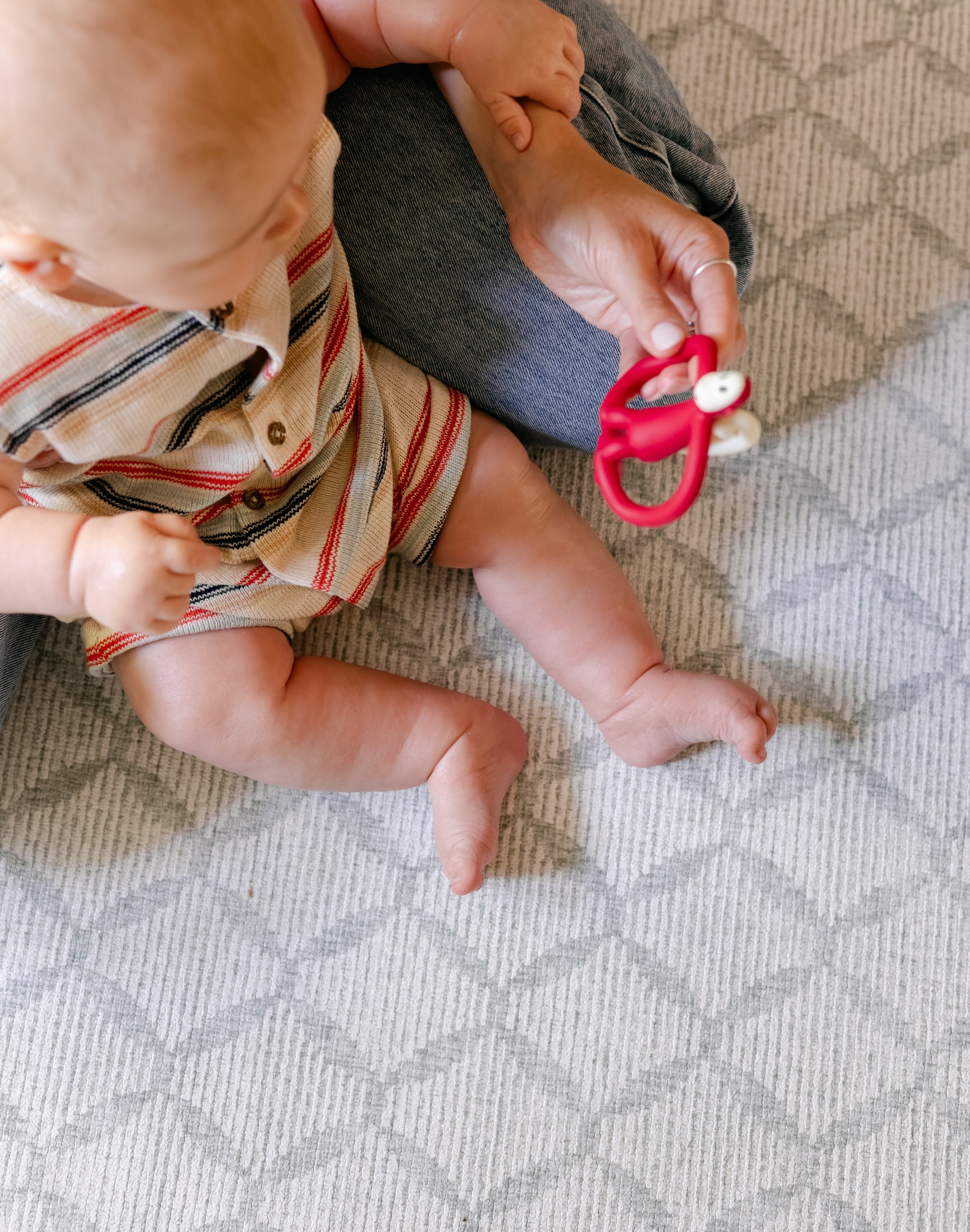 A baby sitting on a safe, comfortable memory foam geometric pattern playmat from totter and tumble 