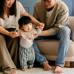 A family helping a baby take it's first steps on the gatherer playmat from totter and tumble made from thick safe memory foam