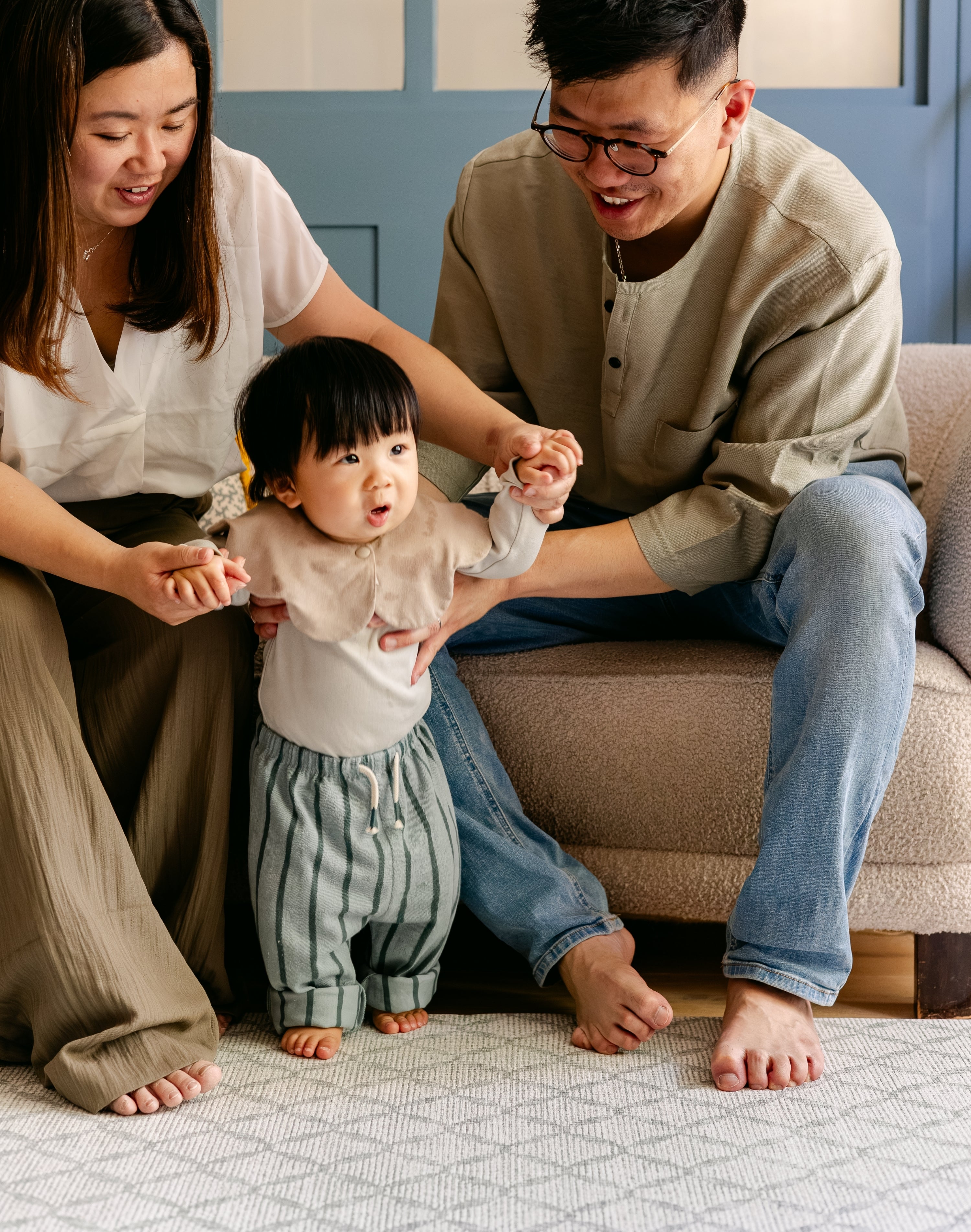 A family helping a baby take it's first steps on the gatherer playmat from totter and tumble made from thick safe memory foam