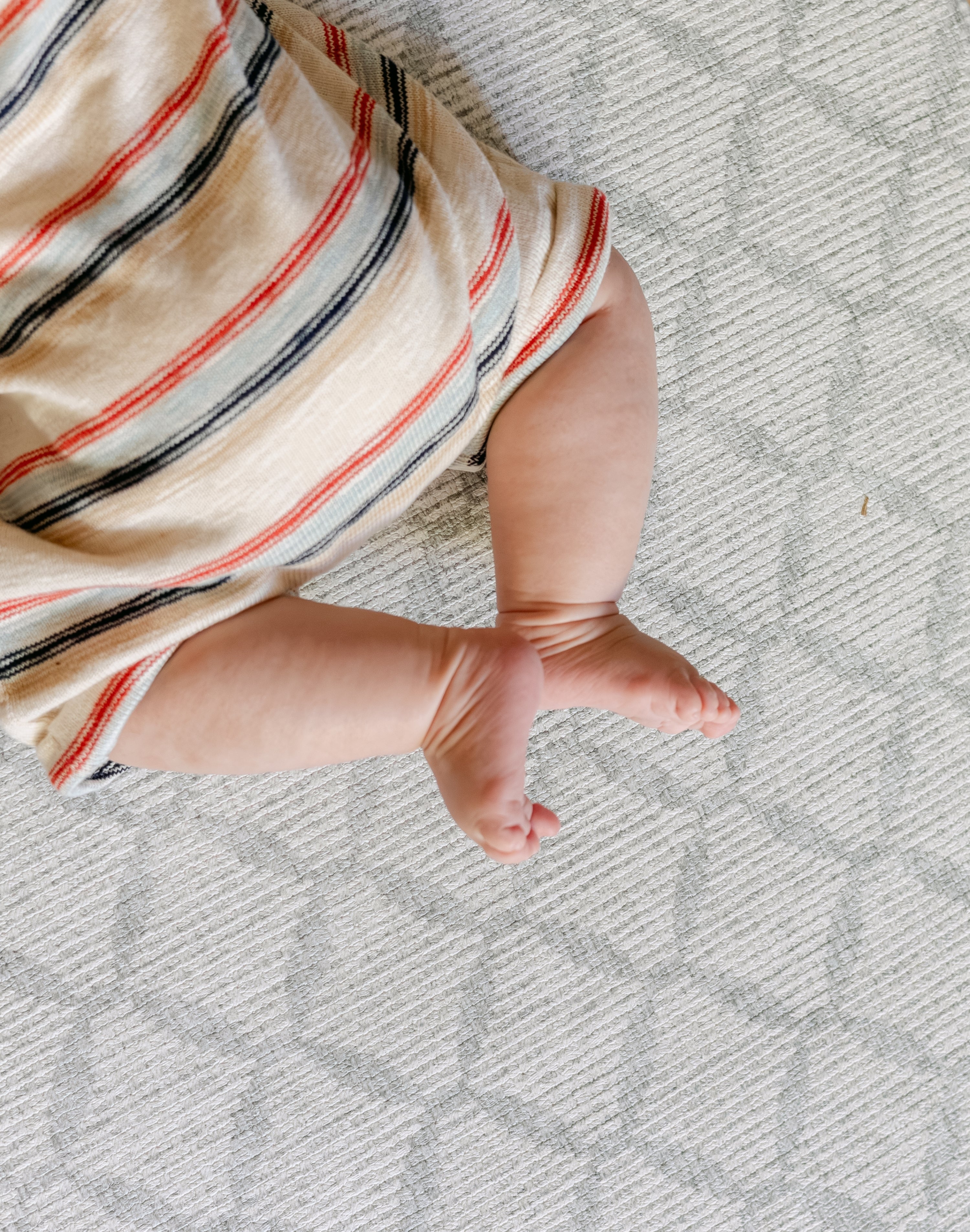 Close up shot of a baby legs laid on a safe, non toxic, The Gatherer playmat from totter and tumble
