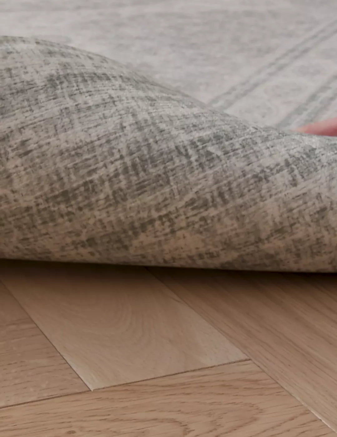 A video of a hand lifting up a rug-like extra large playmat. On the reverse we see a stylish grey patterned deign 