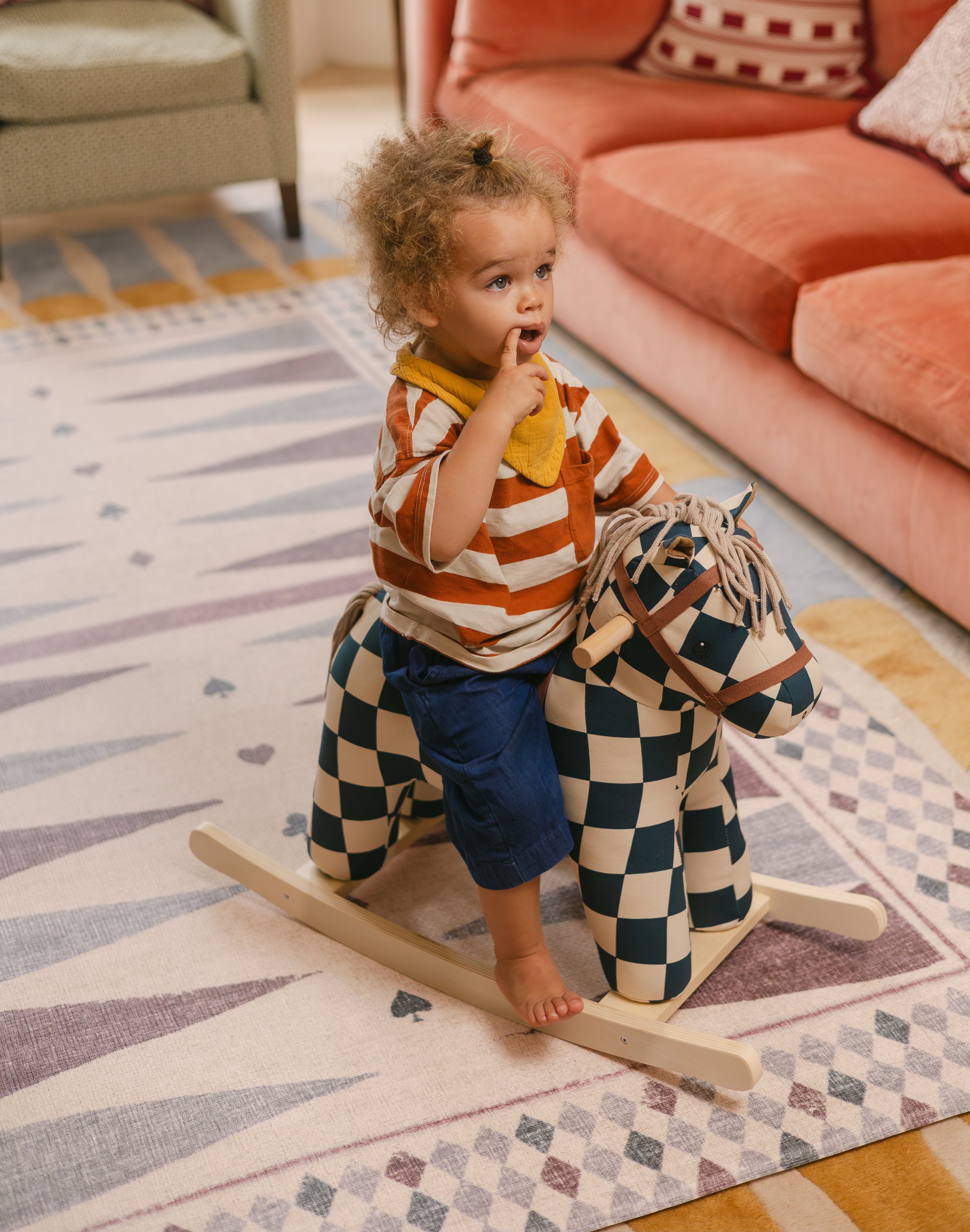 Child on rocking horse on The Roller Playmat by Totter + Tumble, the biggest one piece playmat on the market