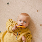 Baby lying on The Wildcard Totter + Tumble reversible wipeable memory foam playmat