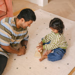 Dad and daughter playing on The Wildcard Totter + Tumble reversible wipeable memory foam playmat