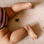 Baby's legs and toes lying on The Wildcard Totter + Tumble reversible wipeable memory foam playmat