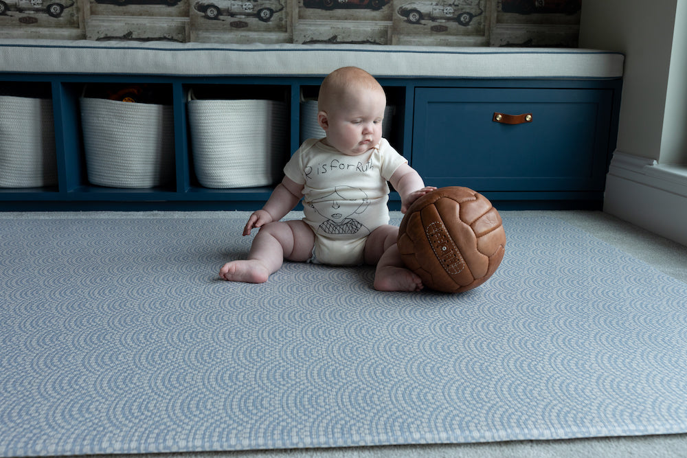 Baby playing on the reversible baby playmat The Seafarer and The Keeper luxury memory foam one piece stylish baby playmat